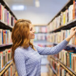 Deposit Photos stock image of a woman looking at books in a library